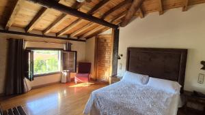 a bedroom with a bed and a chair in a room at Antiguas Eras La Alberca in La Alberca
