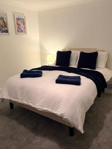 a bedroom with a large bed with two blue pillows at The Dearham Lonnin Nook in Dearham