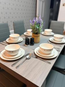 a wooden table with plates and silverware on it at The Dearham Lonnin Nook in Dearham