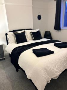 a bedroom with two beds with black and white pillows at The Dearham Lonnin Nook in Dearham