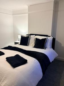 a bedroom with a large bed with black and white pillows at The Dearham Lonnin Nook in Dearham