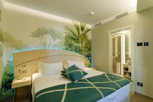 a bedroom with a bed with a painting on the wall at Color Hotel Style, Design & Gourmet in Bardolino