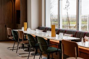 a conference room with a long table and chairs at Hampton by Hilton Bordeaux Merignac Airport in Mérignac +43 photos