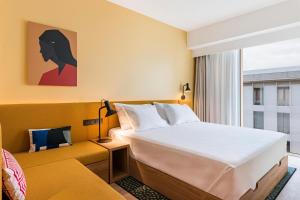 a hotel room with a large bed and a window at Hampton by Hilton Bordeaux Merignac Airport in Mérignac