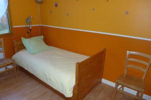a small bed in a room with two chairs at Valériane in Froncles
