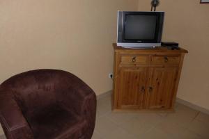 a leather chair and a television on a wooden cabinet at Valériane in Froncles