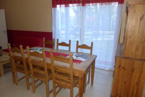 a wooden table and chairs in a kitchen with a window at Valériane in Froncles +2 photos