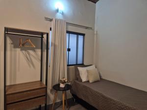 a small bedroom with a bed and a window at Kitnet Vale do Amanhecer - Templo Mãe in Planaltina
