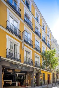 a yellow building with balconies on a street at Abalú Collection Hotel Life Gran Via in Madrid