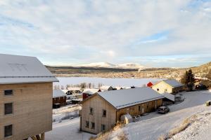 a small town with snow covered buildings and a lake at Olen Village - Funäsdalen in Funäsdalen