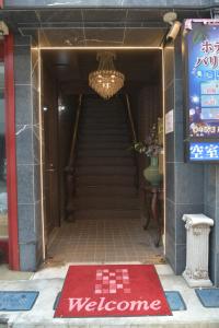 a stairway with a welcome mat in front of a building at Hotel Bali Yokohama in Yokohama