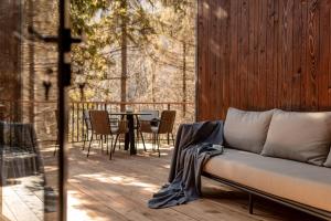 a couch on a deck with a table and chairs at Veres Hill in Tukhlya