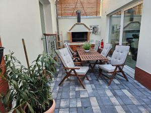 a patio with a wooden table and chairs and a fireplace at Marcel Apartments Leipzig in Leipzig