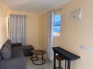 a living room with a couch and a table at Comfortable and affordable in Saint Georgeʼs