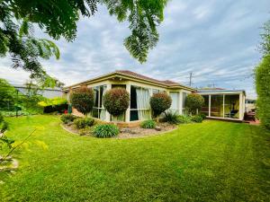 a house with a lawn in front of it at Brightside , Great family home near Airport in Craigieburn