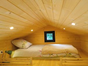 a bed in a log cabin with a ceiling at Tiny somniflore in Wasigny