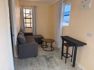 a living room with a couch and a table at Comfortable and affordable in Saint Georgeʼs +18 photos