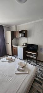 a hotel room with two beds and a sink at Флора Поморие in Pomorie