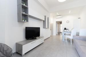 a living room with a flat screen tv on a white wall at The Sea Under the House in Marina di Strongoli +12 photos