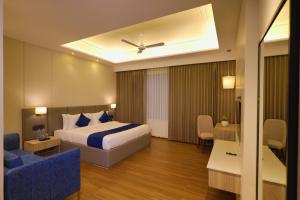 a hotel room with a bed and a blue couch at BB Grand in Sunām