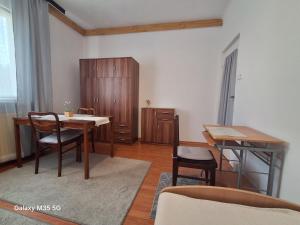 a dining room with a table and chairs and a cabinet at ,,Arts Home,, ,ZAPRASZAM ,blisko las,dużo przyrody, blisko centrum kardiologii,centrum szkoleniowe,trasa na Lublin,Ukrainę,mieszkanie przestronne,czyste,spokojna okolica,blisko Aldi,Lidl,Żabka,Rossmann,pkp, ztm in Warsaw
