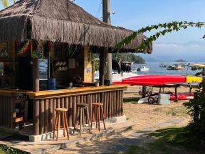 a bar on the beach with a straw hut at MAMBEMBE hostel - Ilha Grande, Vila do Abraão in Abraão