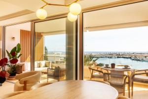 a living room with a table and chairs and a large window at Apartamento Pink Frontline Premium in Torrevieja