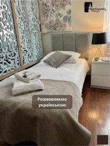 a bedroom with a bed with two towels on it at Apartamenty Przemyśl in Przemyśl