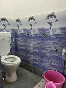 a bathroom with a toilet and dolphins on the wall at Narayan homestay guesthouse in Ayodhya +13 photos