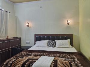 a bedroom with a bed and two lights on the wall at Narayan homestay guesthouse in Ayodhya