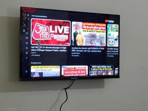 a flat screen tv hanging on a wall at Narayan homestay guesthouse in Ayodhya