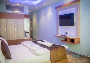 a bedroom with a bed with a tv on the wall at HN Guest House in Shillong