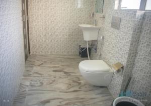 a bathroom with a white toilet and a sink at HN Guest House in Shillong +20 photos