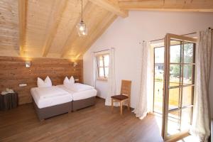 a bedroom with two beds and a large window at Pension Schweizerhaus Garni in Weyarn