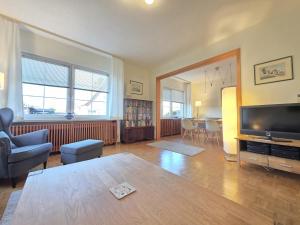 a living room with a table and a tv and a couch at Ferienhaus Teddis Haus in Norden