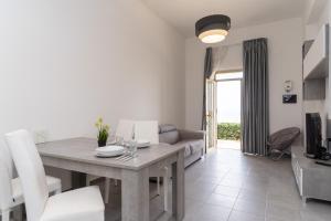 a dining room and living room with a table and chairs at The Sea Under the House in Marina di Strongoli