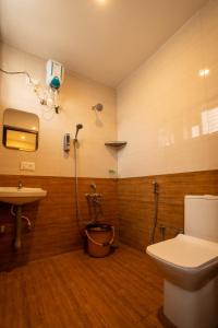 a bathroom with a toilet and a sink and a shower at Aafiya lakeview Apartments in Coimbatore