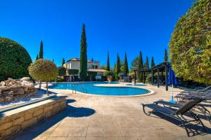 a swimming pool in a yard with trees at 2 bedroom Apartment Avdimou with stunning sea views, Aphrodite Hills Resort in Kouklia
