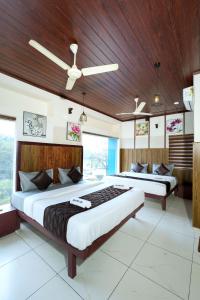 a bedroom with two beds and a wooden ceiling at Velan Temple View in Palni +209 photos