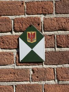 a green and white envelope on a brick wall at In het koetshuis in Apeldoorn