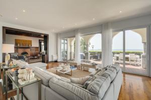 a living room with a large couch and a large window at Blissful Seafront in Cascais