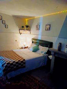 a bedroom with a large bed with lights on the wall at Alojamento Excalibur in Meda
