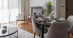 a living room with a dining table and chairs at Burj Khalifa View & Creek lagoon in Dubai