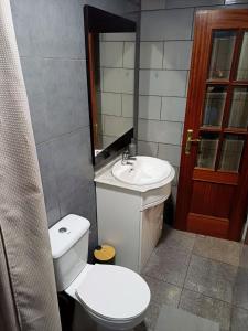 a bathroom with a white toilet and a sink at Alojamento Excalibur in Meda