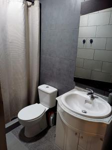 a bathroom with a toilet and a sink at Alojamento Excalibur in Meda