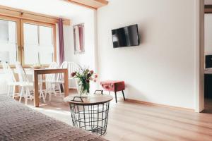 a living room with a table and a tv on a wall at Haus Luna - Apartment Luna 6 in Schwangau