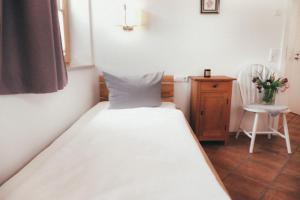 a small bedroom with a bed and a chair at Haus Luna - Apartment Luna 6 in Schwangau