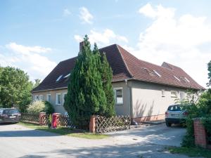 a house with a large tree in front of it at Ferienwohnung am Haff in Ueckermünde