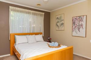 a bedroom with a bed with a basket on it at Brightside , Great family home near Airport in Craigieburn
