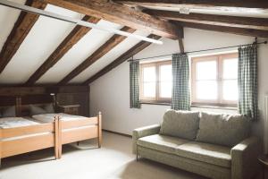 a bedroom with a bed and a couch and windows at Luna Mia - Apartment 5 in Schwangau